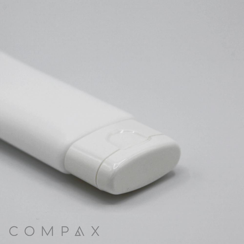 A close-up image of a "35mm Flat Flip Top" white plastic tube with a flip-top cap, positioned on a light grey background. The cap is closed, and the tube features a clean and simple design. The brand name "COMPAX" is partially visible in the lower left corner.