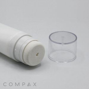 Close-up of a 35mm Sponge Applicator, featuring a white cylindrical tube with a sponge applicator tip, positioned horizontally on a plain white surface. Beside it is a transparent plastic cap. The word "COMPAX" is partially visible in light grey text at the bottom left of the image.