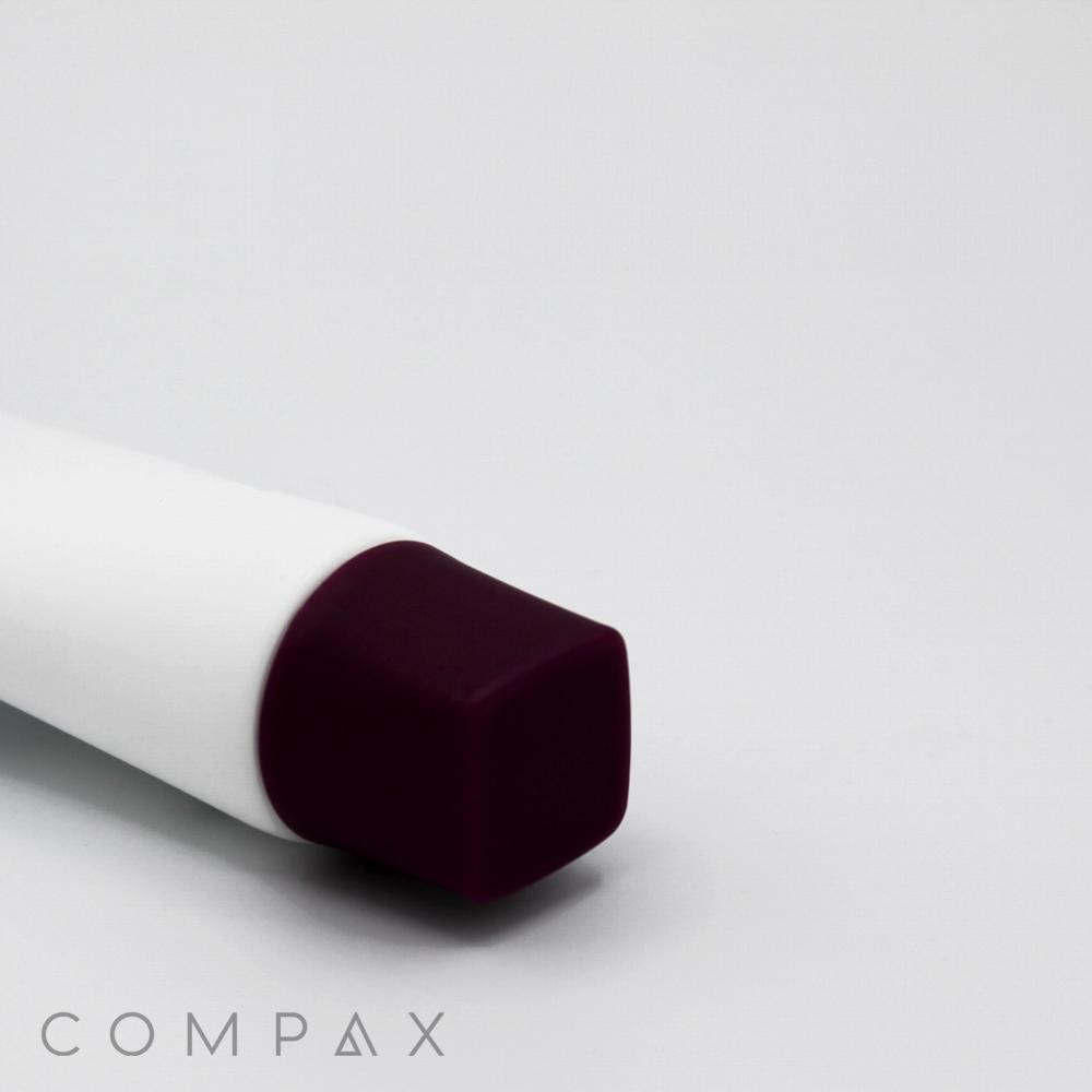 A close-up of a white cylindrical 35mm Screw Top featuring a dark purple, square-shaped cap set against a plain gray background. The word "COMPAX" is visible in the bottom left corner.