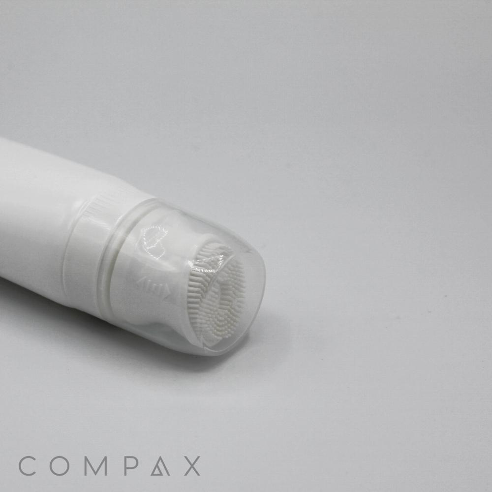 The 40mm Silicone Brush Applicator is a white cylindrical bottle featuring a transparent cap that covers a small brush at the top, both integrated into the bottle's design. The word "COMPAX" is displayed in light grey in the bottom left corner of the image, which has a plain white background.