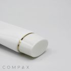 Close-up of a 40mm Oval Screw Top in a white tube with a gold ring near the cap, shown on a light gray background. The word "COMPAX" is positioned at the bottom left corner.