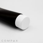 A close-up of a cylindrical black tube featuring a white flip-top cap. The tube is slightly angled, and the focus is on the cap. The word "COMPAX" is visible in the bottom left corner of the image. The background is plain white.