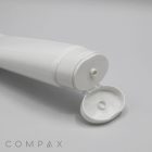 A close-up image of a white, open plastic tube of cream or gel. The tube rests on a light surface with the cap hinged open, revealing a small nozzle. The product name "45mm Oval Flip Top" is printed in a minimalistic font at the lower left corner of the image.
