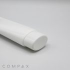 A close-up shot of a white, oval tube with a flip-top cap placed against a plain white background. The word "COMPAX" is printed at the bottom left corner in a minimalist font.