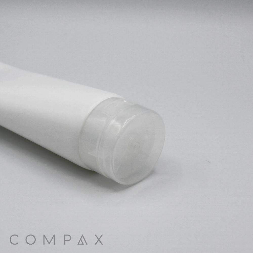 A close-up of a white plastic tube with a clear, round cap lying on its side against a plain light grey background. The product name, "50mm Flip Top," is subtly displayed in the bottom-left corner of the image.