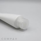 A close-up view of a white, cylindrical plastic tube labeled "50mm Flip Top," featuring a translucent cap and viewed from the side. The tube is positioned at an angle, with the word "COMPAX" visible in the bottom left corner of the image.