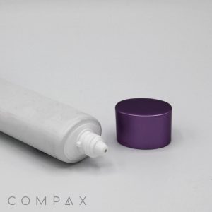 A 30mm Oval Screw Top lying on its side, uncapped, with a purple cylindrical cap placed beside it on a plain white surface. The word "COMPAX" is printed at the bottom left corner of the image.