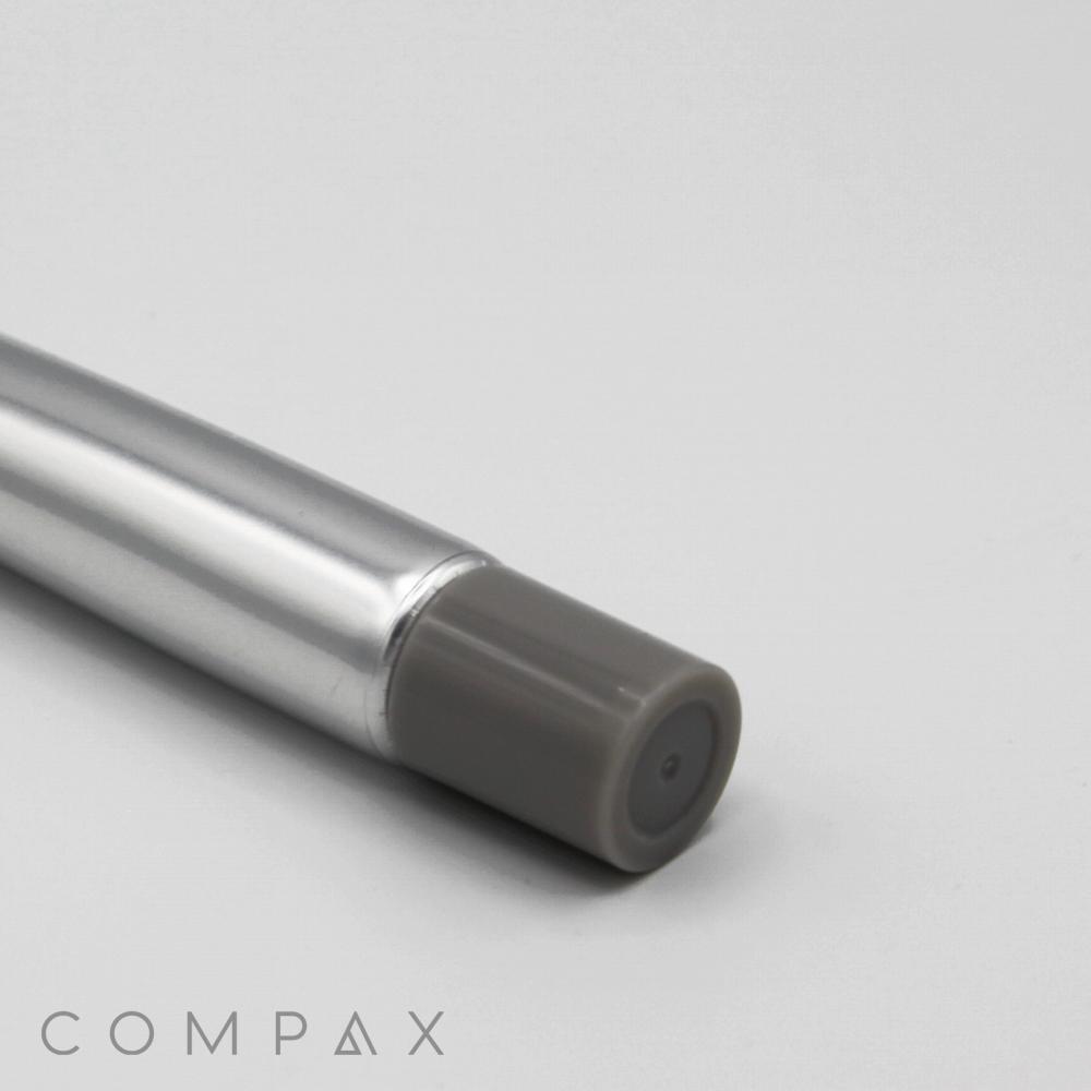 A close-up of a sleek, metallic gray "19mm Needle Nose" with a dark gray cap on a white background. The marker's cylindrical body features a shiny, reflective finish, and the word "COMPAX" is partially visible in the bottom left corner.