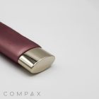 A sleek, bronze-colored tube with a shiny, gold-colored cap, lying horizontally on a white background. The product appears to be a cosmetic or personal care item. In the lower-left corner, the word "COMPAX" is visible in light grey text. This elegant item is named the 35mm Oval Screw Top.