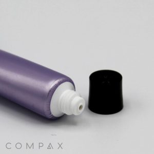 A close-up image of a purple 16mm Screw Top tube with a white nozzle, lying horizontally. The black cap is removed and placed next to the nozzle. The word "COMPAX" appears in the bottom left corner. The background is plain white.