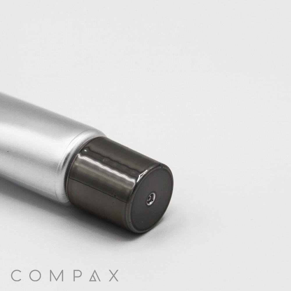 A close-up of a cylindrical metallic object with a shiny cap, identified as a "16mm Screw Top," displayed against a plain white background. The word "COMPAX" is written in the lower left corner.