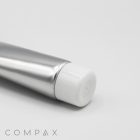 A close-up view of a silver aluminum tube labeled "25mm Screw Top" with a white cap on a plain white background. The bottom right corner of the image features the word "COMPAX" in gray, stylized text.