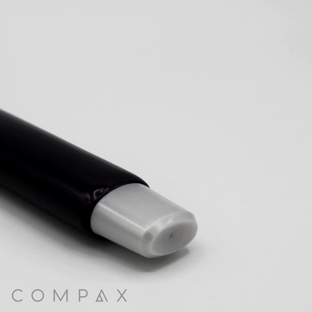 Close-up of a black cylindrical object with a gray tip against a plain white background. The object appears to be the 25mm Oval Needle Nose. The word "COMPAX" is lightly printed in gray at the bottom left corner of the image.