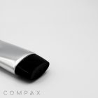 A close-up photo of a 35mm Oval Screw Top, featuring a silver tube with a black cap, positioned at an angle against a plain white background. The word "COMPAX" is visible in gray text at the bottom-left corner.