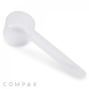 A 20cc Scoop, made of transparent plastic and featuring a long handle, is placed against a plain white background. The subtle branding "COMPAX" is visible in the bottom left corner of the image.