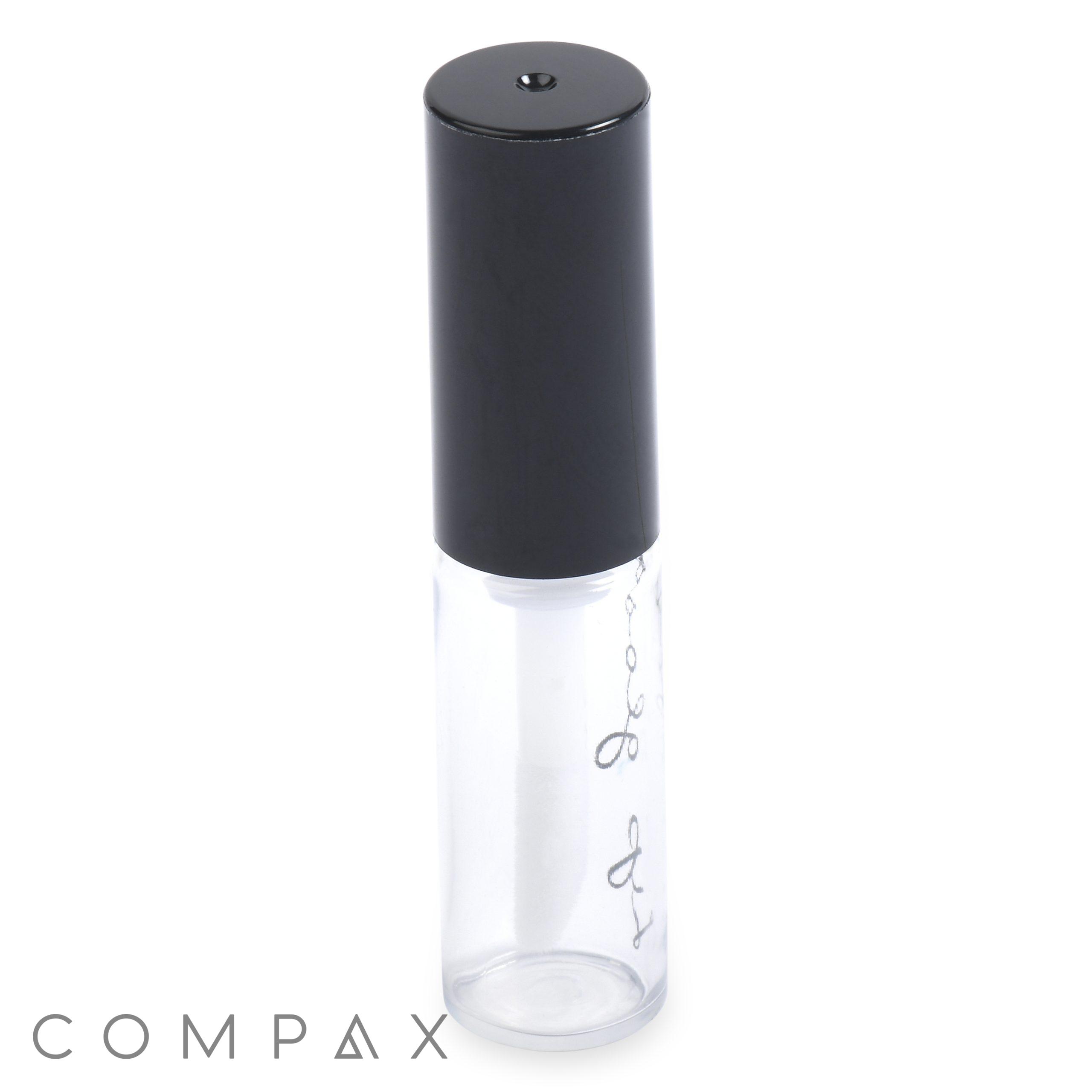 The Round Lip Gloss Bottle is a clear, cylindrical glass container with a black, cylindrical twist-off cap. The bottle seems to be empty and stands upright, featuring faint writing on the glass.
