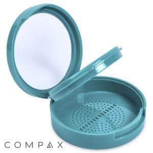 The Single Pan Round Compact is an open, round, teal plastic container featuring a mirror on the underside of the lid and perforations at the bottom for drainage, making it ideal for storing cosmetic items or personal grooming tools.