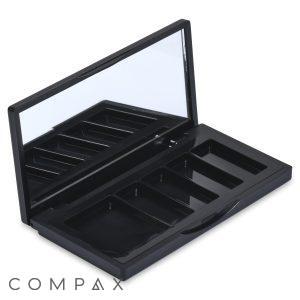 The 5 Well Rectangular Compact, a black, rectangular makeup palette, is shown open with multiple empty compartments. The inner lid features a built-in mirror reflecting part of the compact, and the compartments are designed to hold various makeup products such as eyeshadows or blushes.
