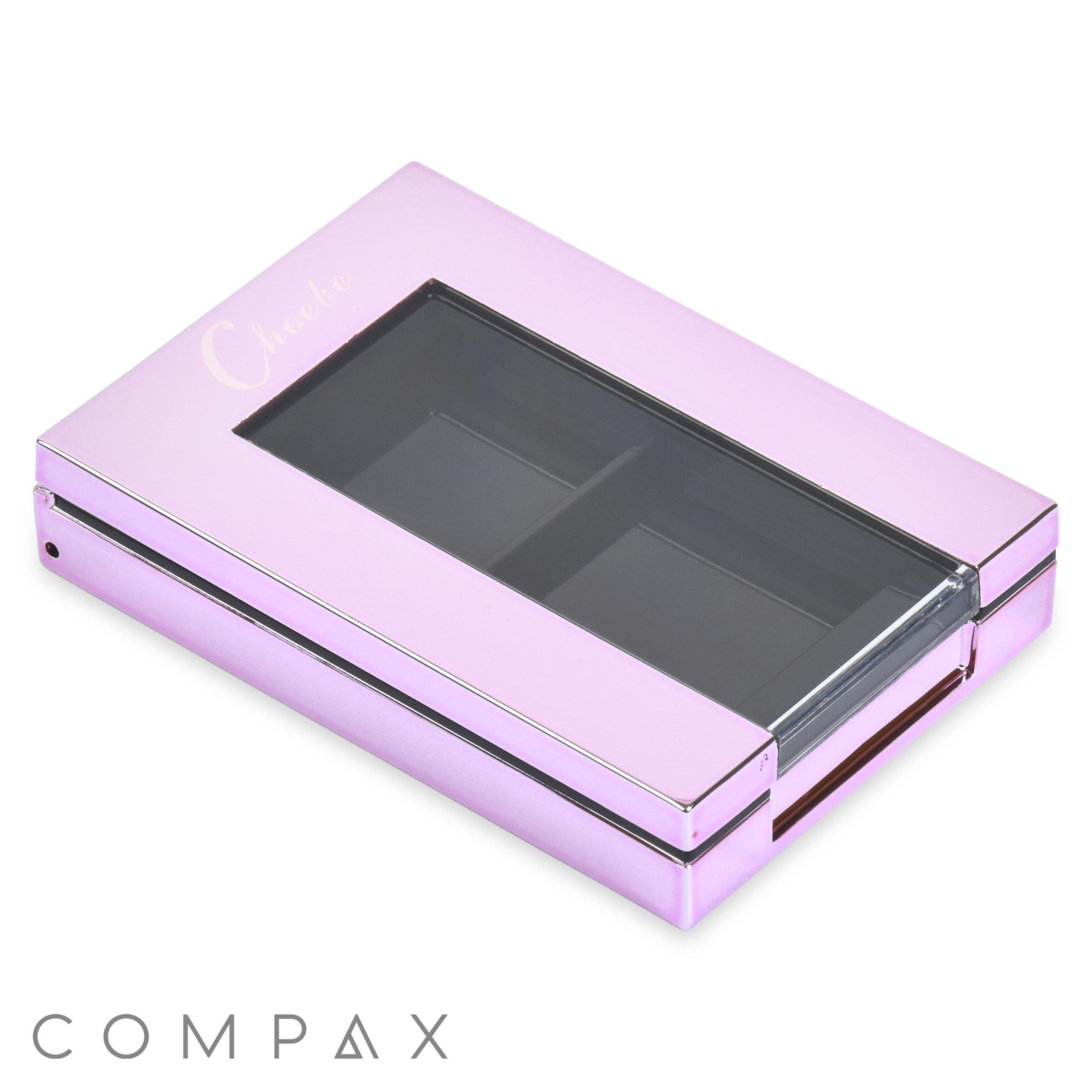 The Double Pan Rectangular Compact is a shiny, rectangular, pink metallic makeup case with a transparent section on the top that reveals two empty compartments inside. It features a sleek design with the word "Cheek" embossed on the top left corner.