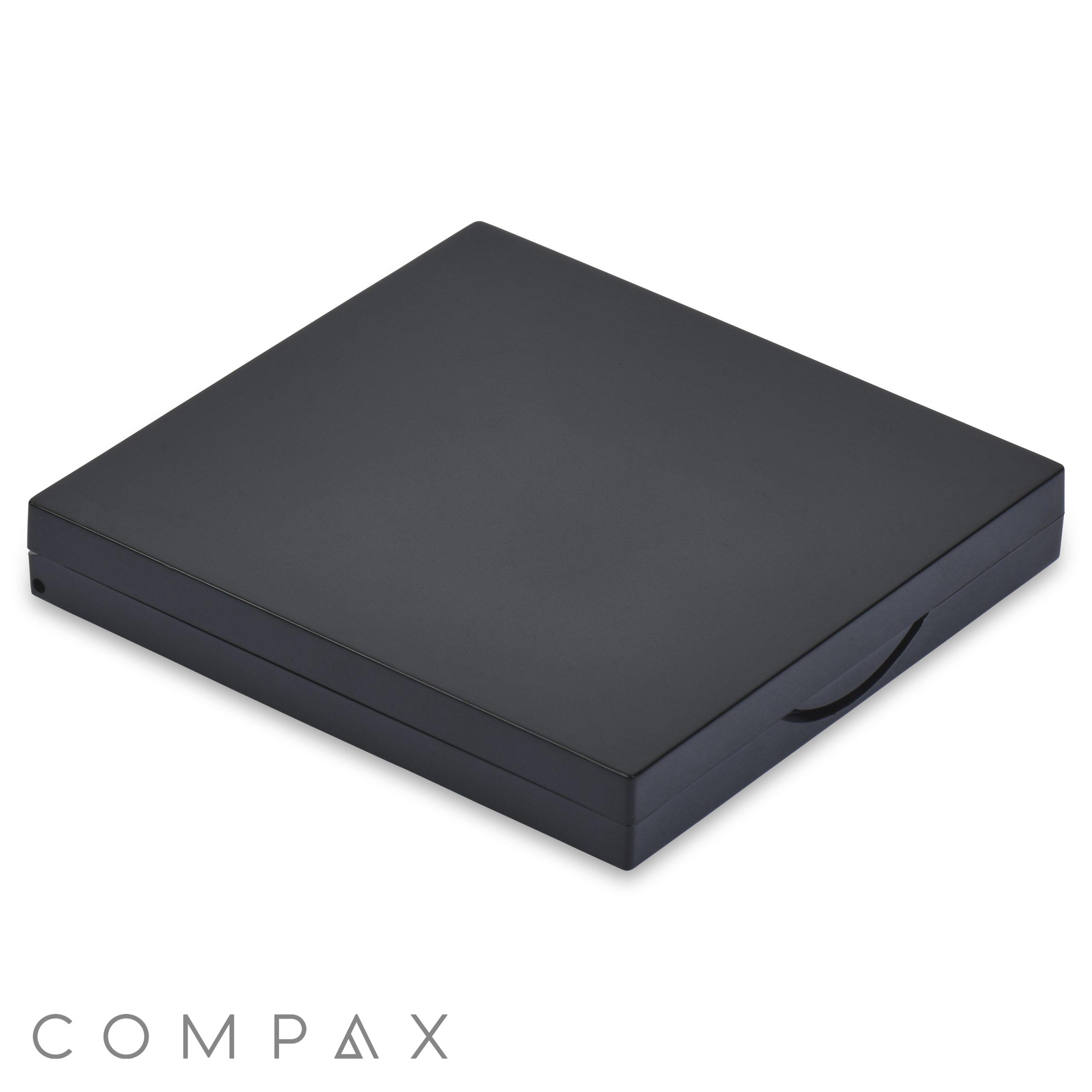 A sleek and minimalist black square compact case, with smooth edges and a subtle latch on the right side. The "4 Well Square Compact with Mirror" is made of a matte material and is shown against a plain white background.