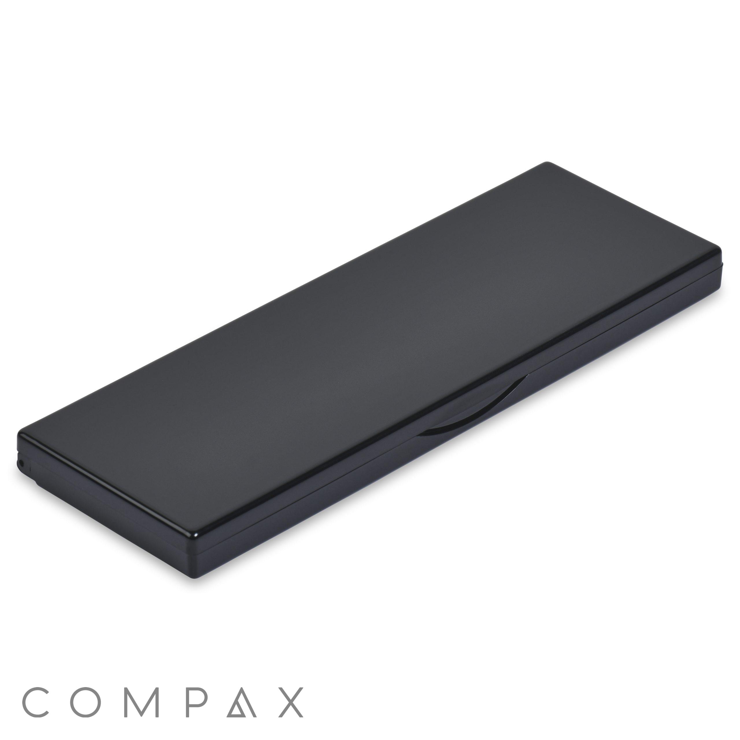 The 4 Well Rectangular Compact with Mirror is a closed black case featuring a minimalist design and a slight curve on the front edge, hinting at its opening mechanism. The case is slim and compact, ideal for storing small items like pens, tools, or other thin objects.