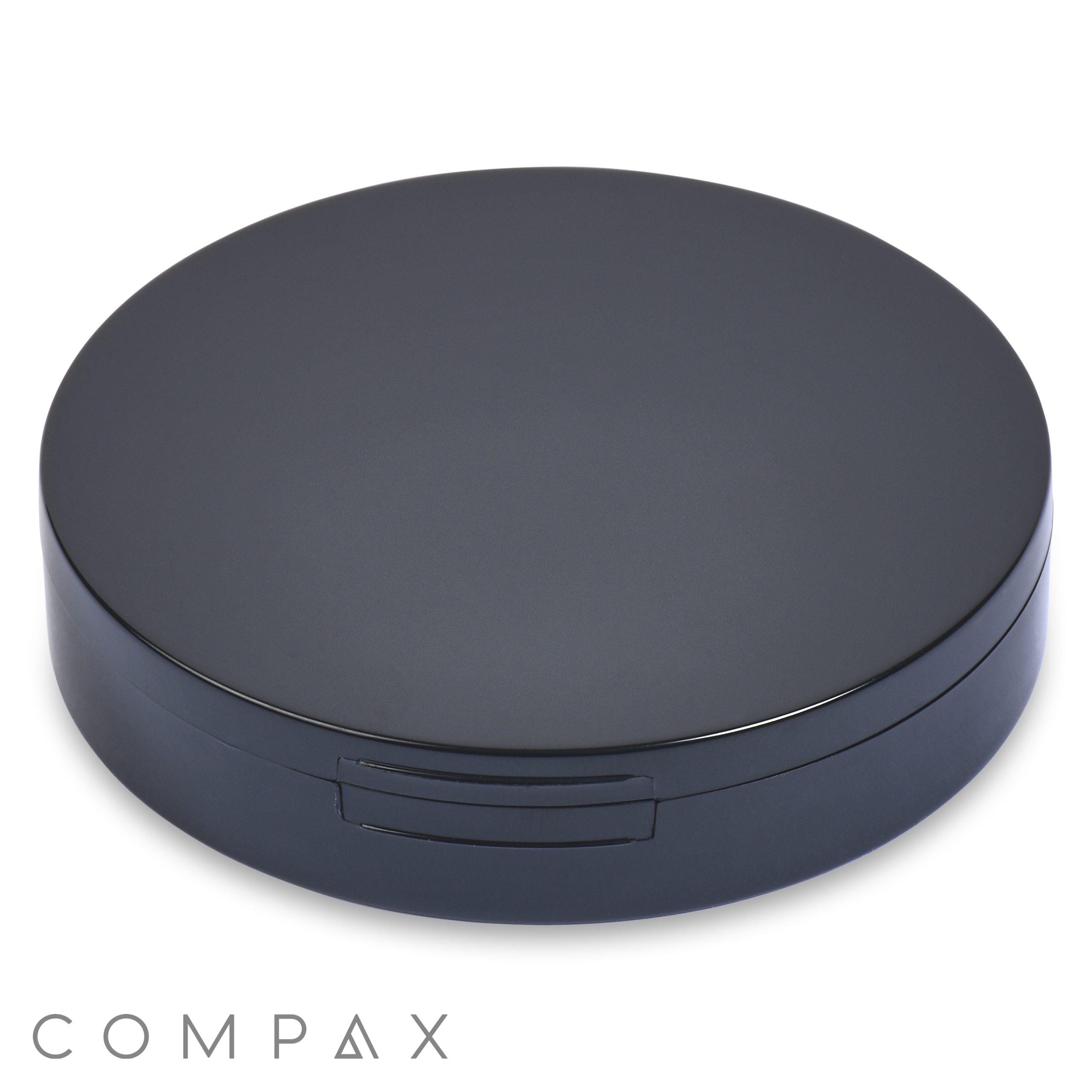 The Single Well Round Compact with Mirror features a sleek, round, black case with a matte finish. It includes a subtle hinge on one side, hinting at its ability to open. The design is minimalistic and modern, completely free of visible logos or designs.