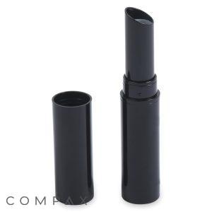 The Round Lipstick, featuring a sleek and modern design, showcases its lighter-colored lipstick inside a black cylinder-shaped case with the cap removed. The cylindrical cap, standing upright next to the open product, complements the overall aesthetic.