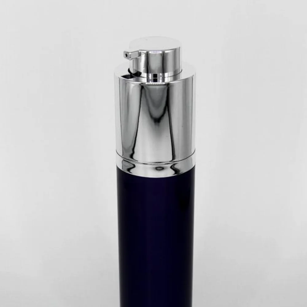 A dark blue airless pump bottle with a silver pump dispenser top.