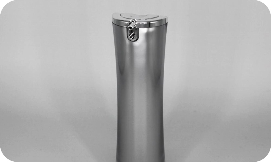 A tall metallic trash can with a sleek design stands against a plain background. The can features a rounded shape and a top flap lid with a lock on the front.