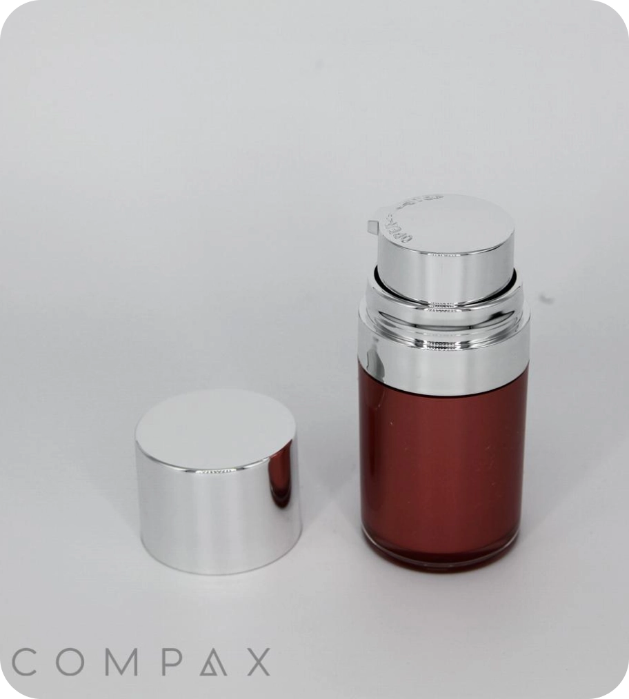 A sleek, metallic red and silver bottle with a removable cap is displayed against a plain white background. The brand name COMPAX is visible in the lower-left corner.